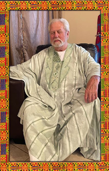 Image of Awo Falokun siting in a chair, he is a man with white hair and a beard wearing a white robe